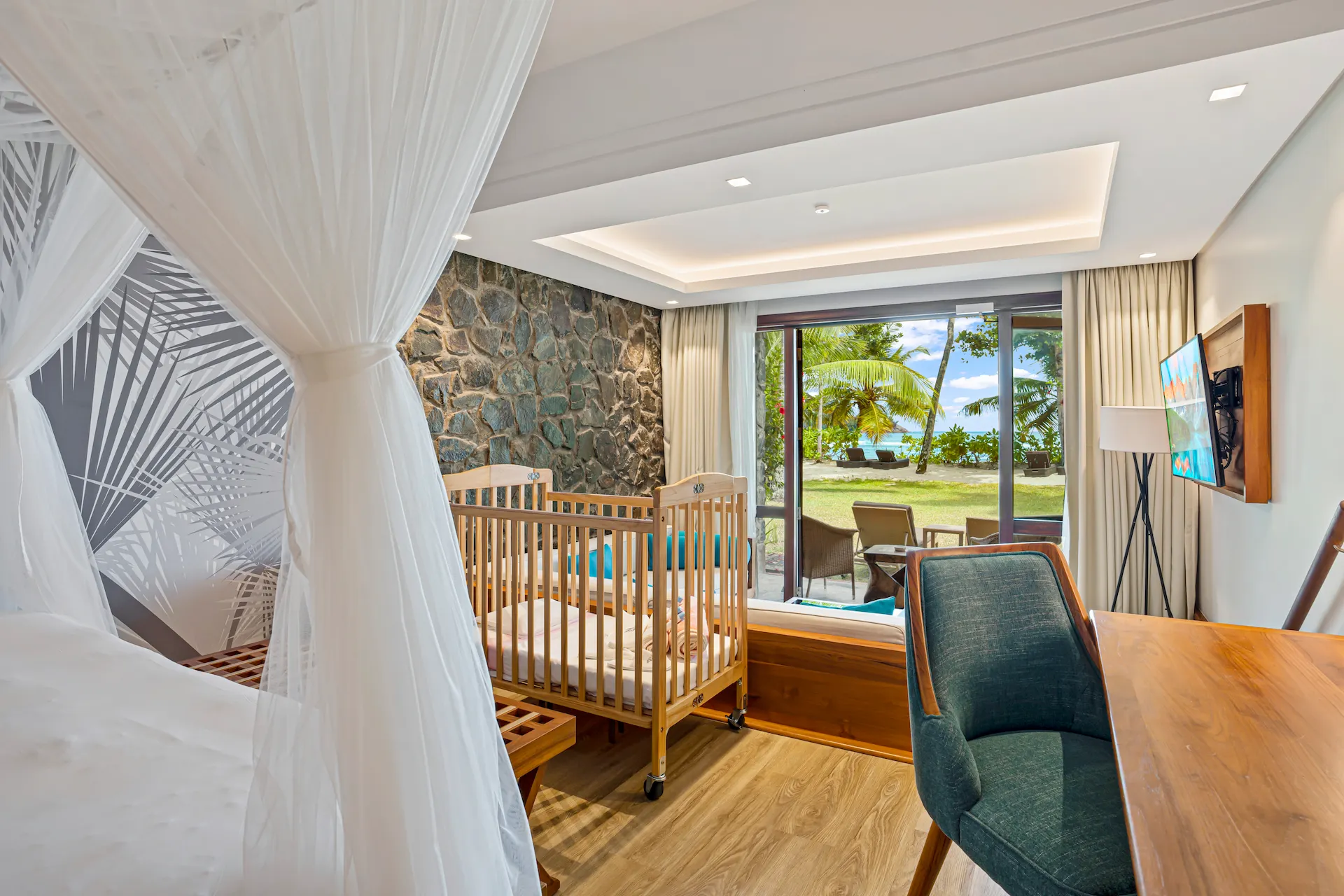 kempinski seychelles resort family room with cot and view of ocean