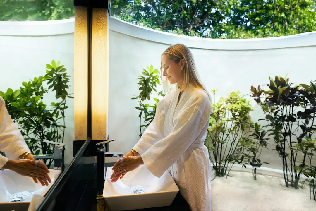 komandoo maldives beach villa bathroom with model overlooking serene island luxury