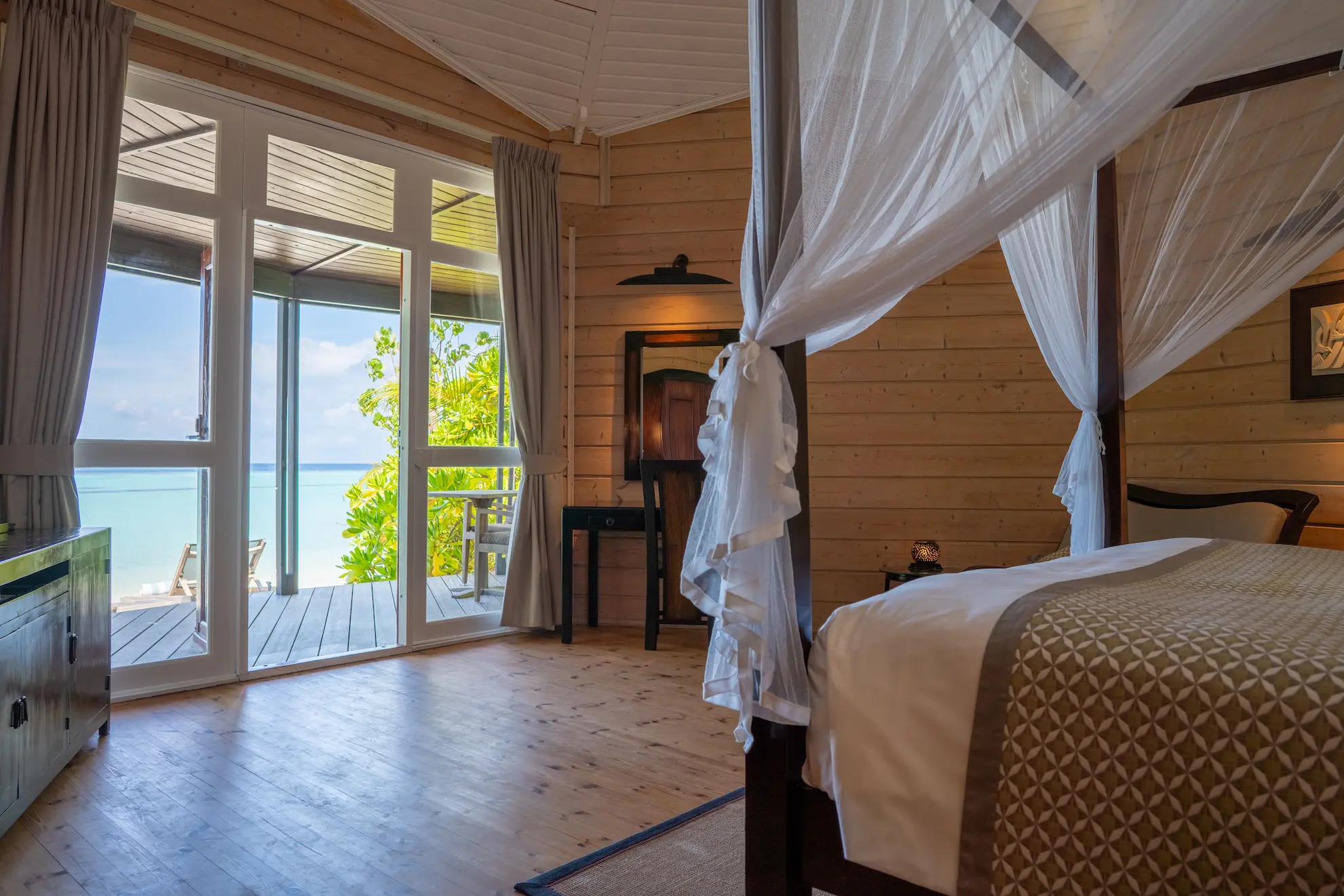 komandoo maldives beach villa interior showcasing a serene luxury bedroom by the island lagoon