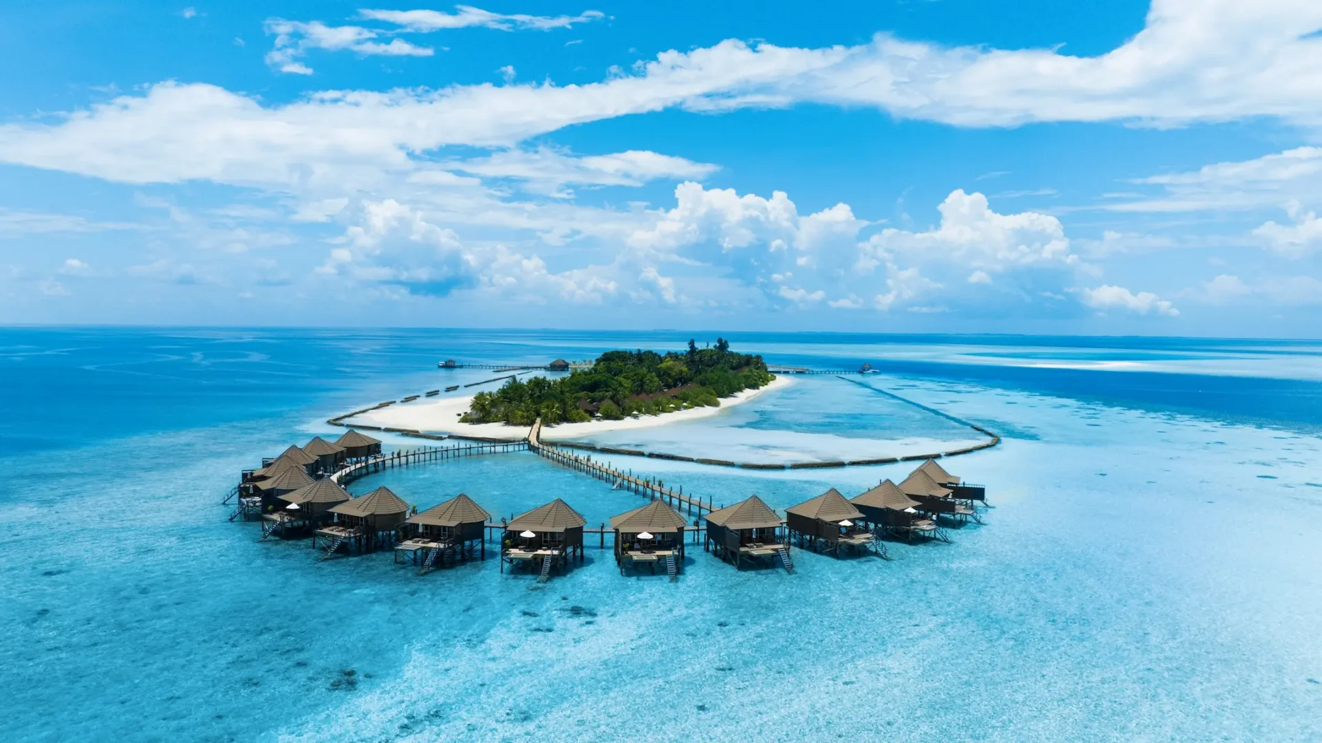 komandoo maldives ocean jacuzzi water villa aerial view showcasing elevated overwater luxury and sweeping turquoise lagoon scenery