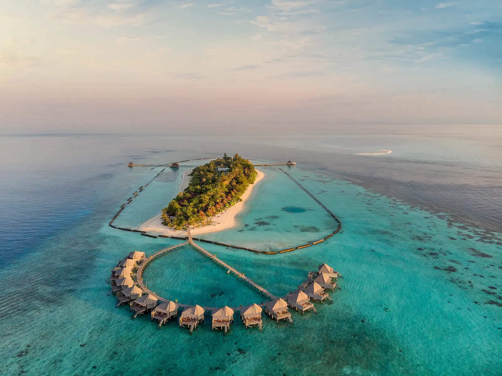 komandoo maldives water villas aerial view showcasing serene overwater luxury and turquoise lagoon scenery