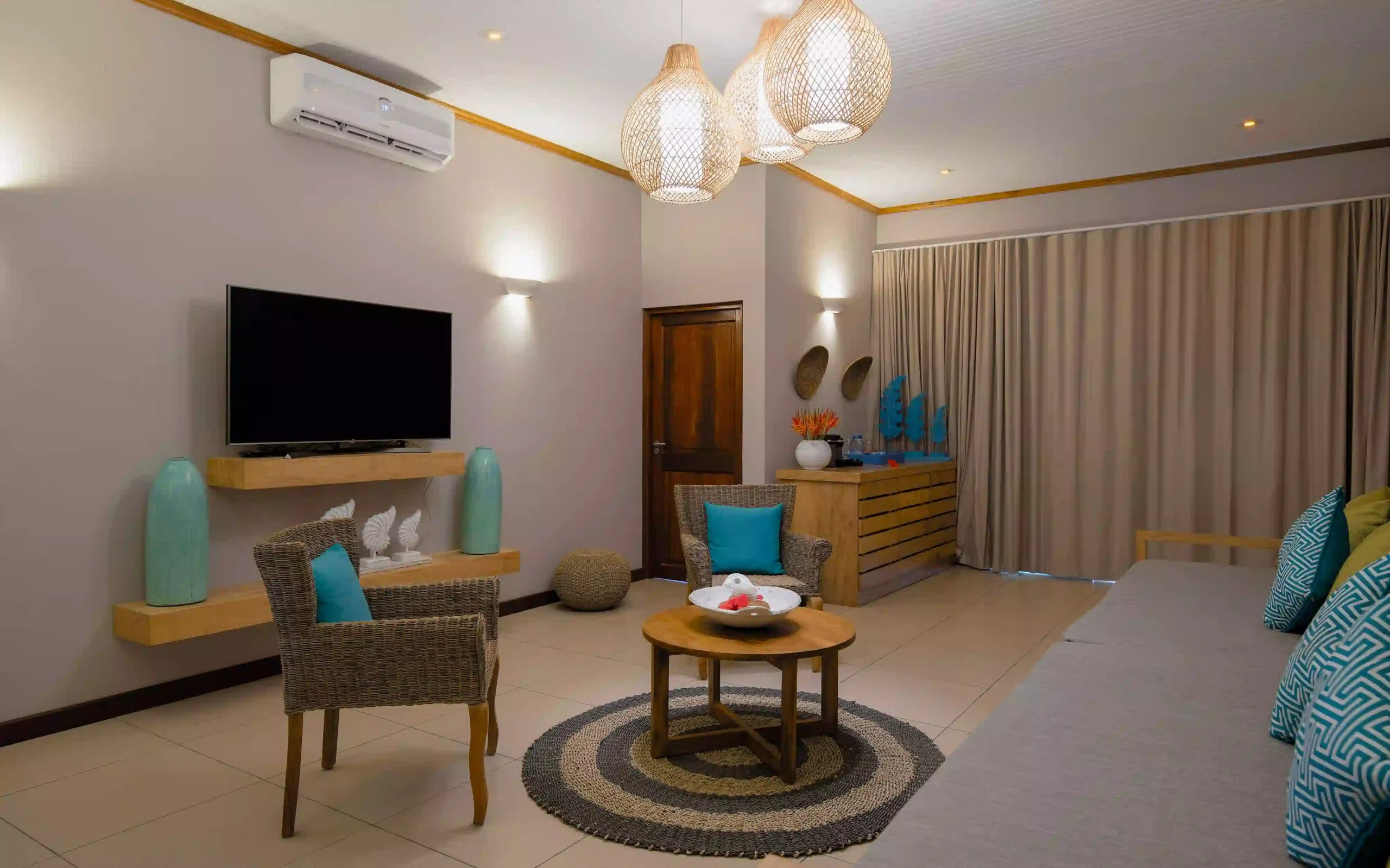 larchipel seychelles family suite bedroom with television and tropical balcony view