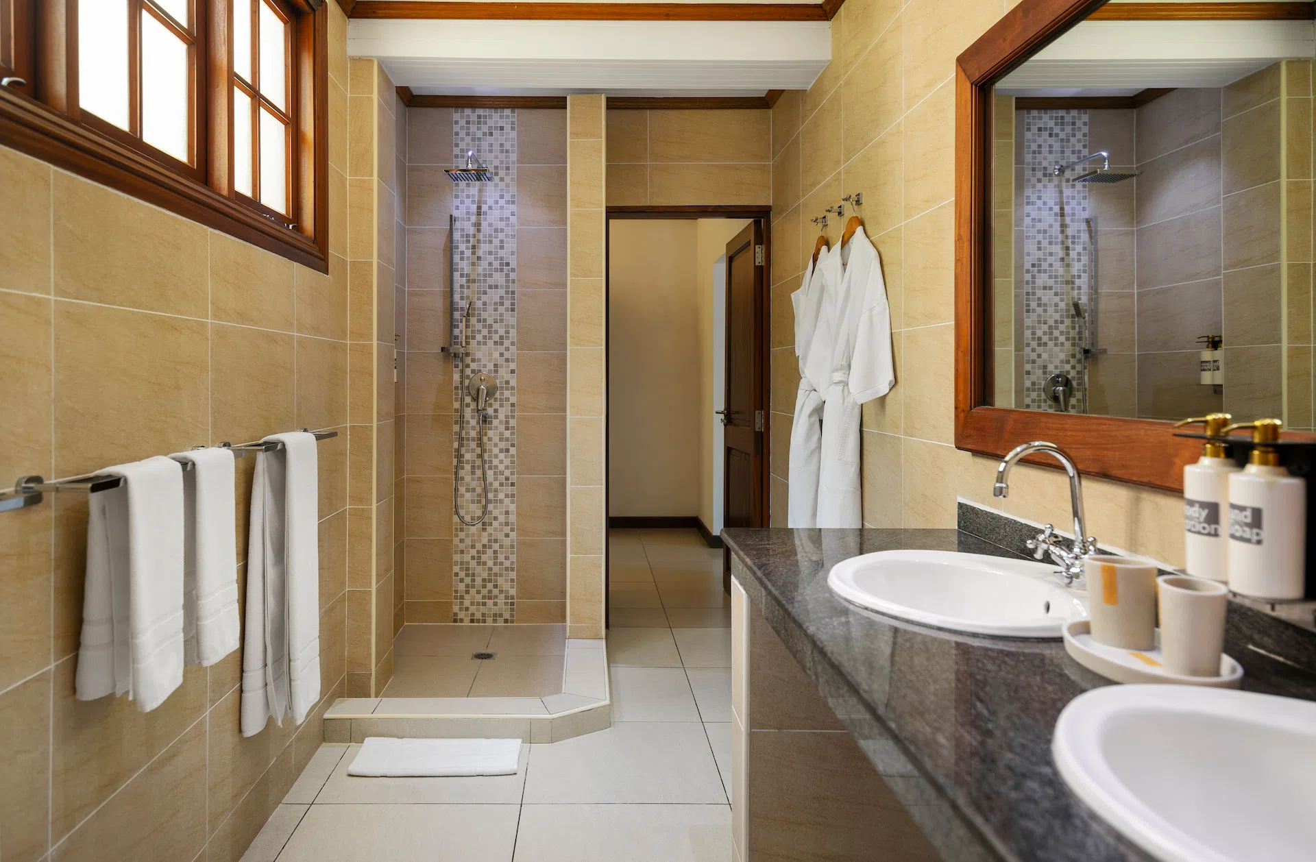 larchipel seychelles superior room bathroom with sinks and shower and tropical decor