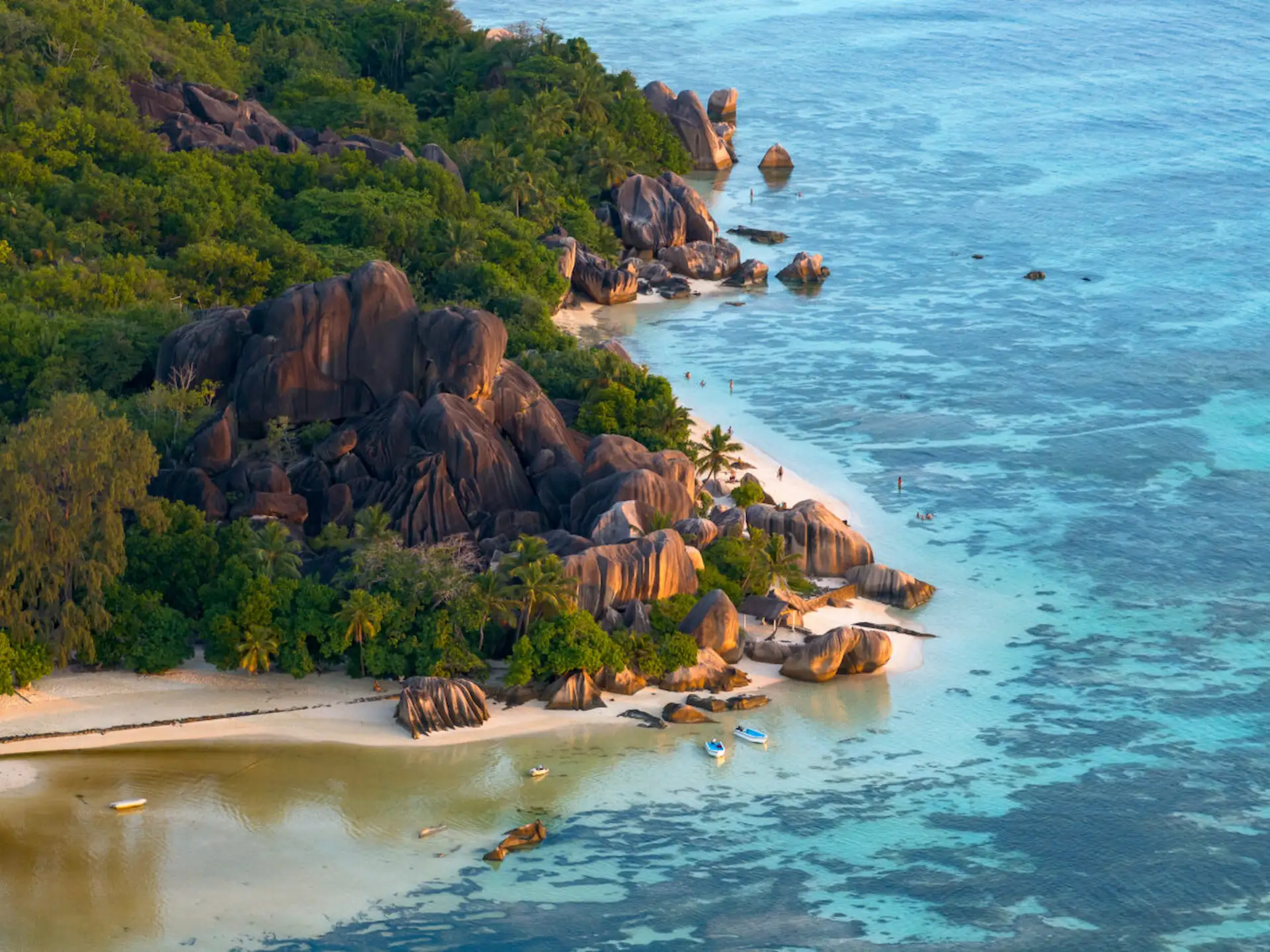 beach along the coast near Le Domaine de L’Orangeraie Resort & Spa with white sand, clear turquoise waters, and tropical surroundings