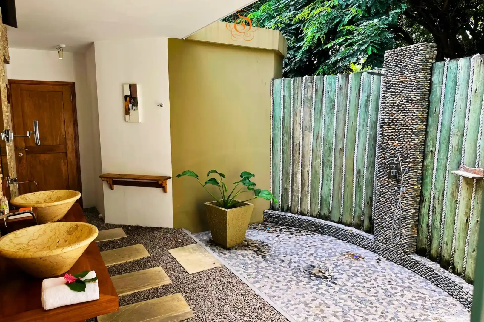 outdoor bathroom in a garden suite at Le Domaine de L’Orangeraie Resort & Spa with open air design surrounded by tropical greenery