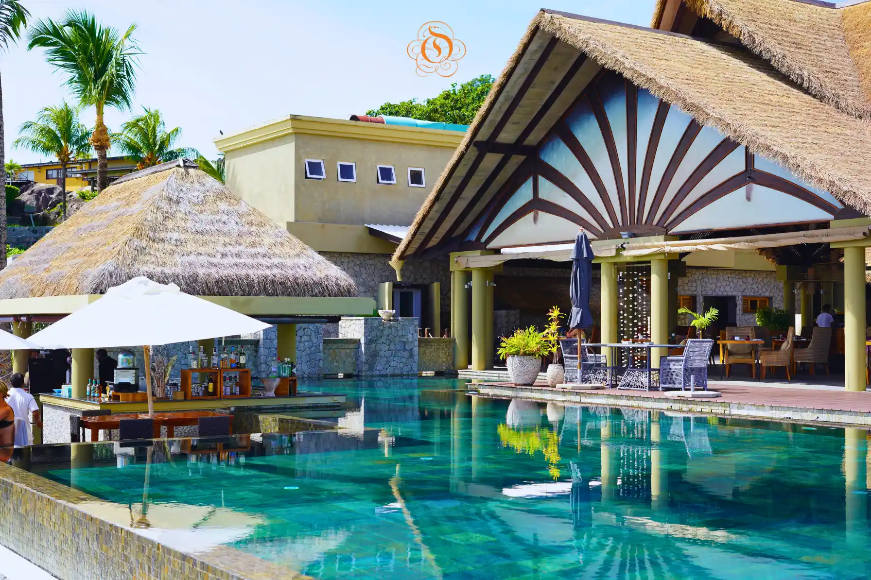 pool bar at Le Domaine de L’Orangeraie Resort & Spa with swim up bar seating and tropical poolside setting