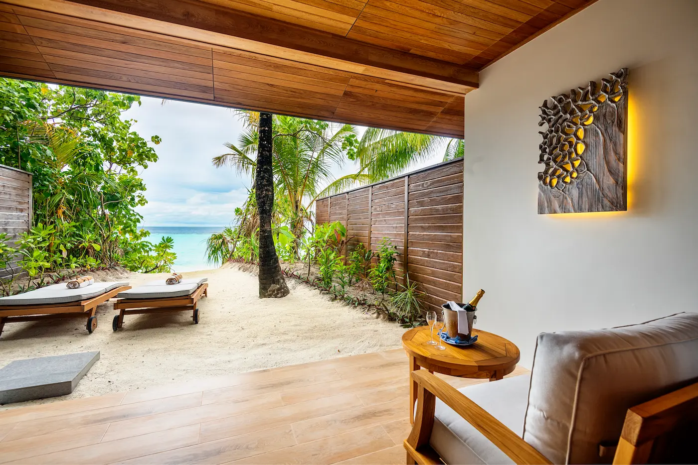 lily beach maldives beach suite deck overlooking the shoreline with elegant open air seating and serene tropical ocean ambience