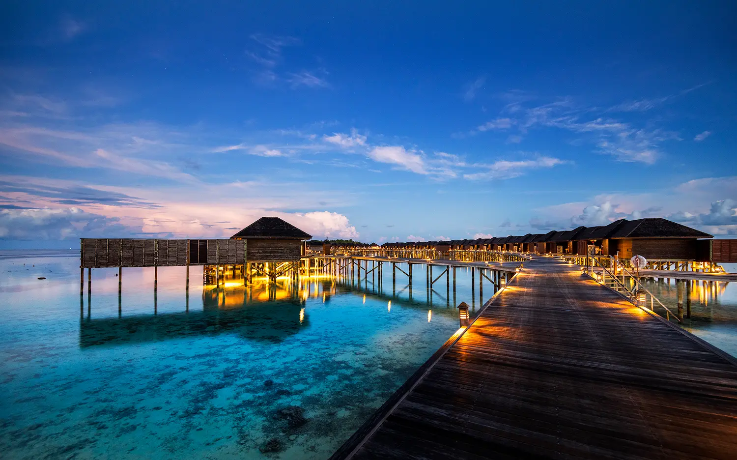 lily beach maldives deluxe water villa jetty extending over the turquoise lagoon with a calm serene tropical atmosphere