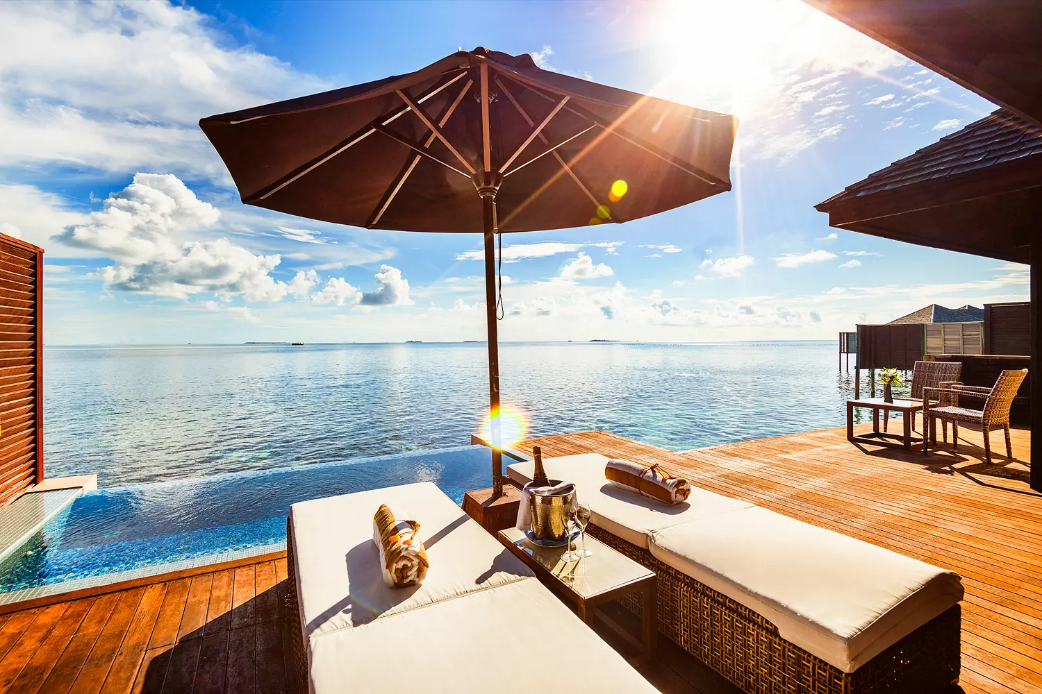 lily beach maldives deluxe water villa terrace overlooking the calm lagoon with a private deck and serene ocean views