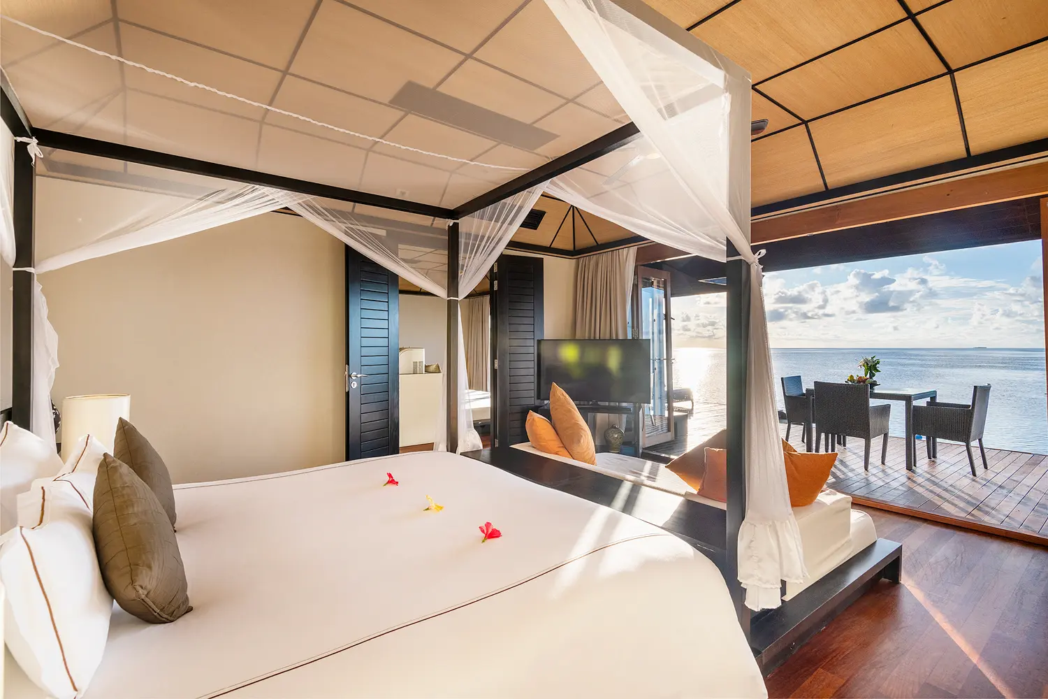 lily beach maldives sunset water suites bed with view overlooking the tranquil lagoon with soft natural light and serene sunset ambience