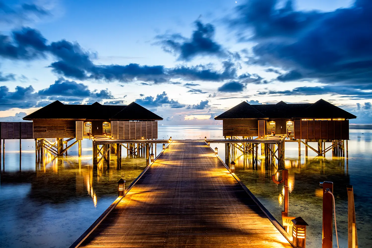 lily beach maldives sunset water suites exterior set above the tranquil lagoon with elegant wooden architecture and serene sunset ocean views