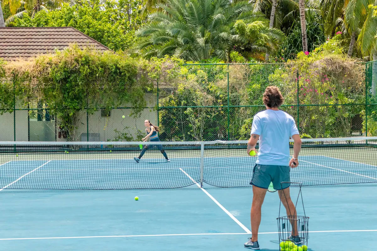 lily beach maldives tennis court surrounded by tropical greenery