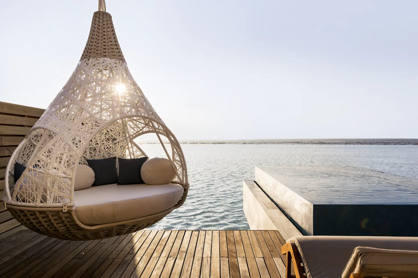lux south ari atoll overwater infinity pool villa day bed with serene lagoon facing relaxation space