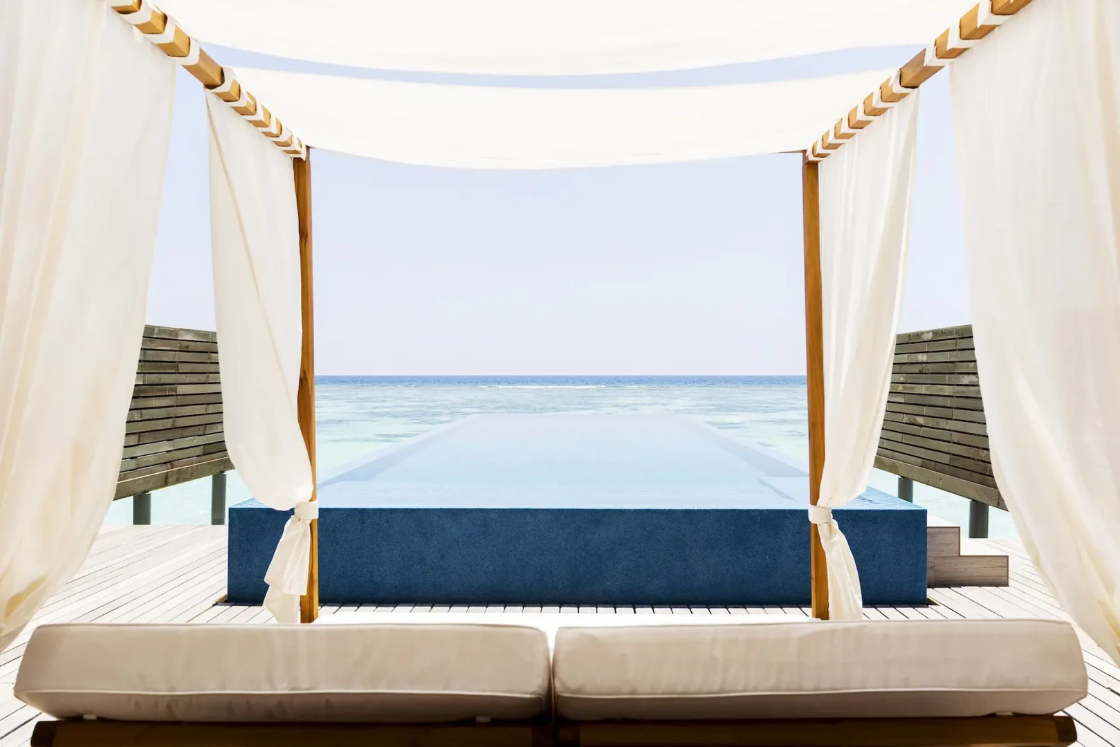 lux south ari atoll temptation pool water villas daybed overlooking the tranquil lagoon