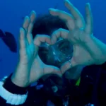 A scuba diver exploring vibrant coral reefs in clear blue waters off the coast of Mauritius