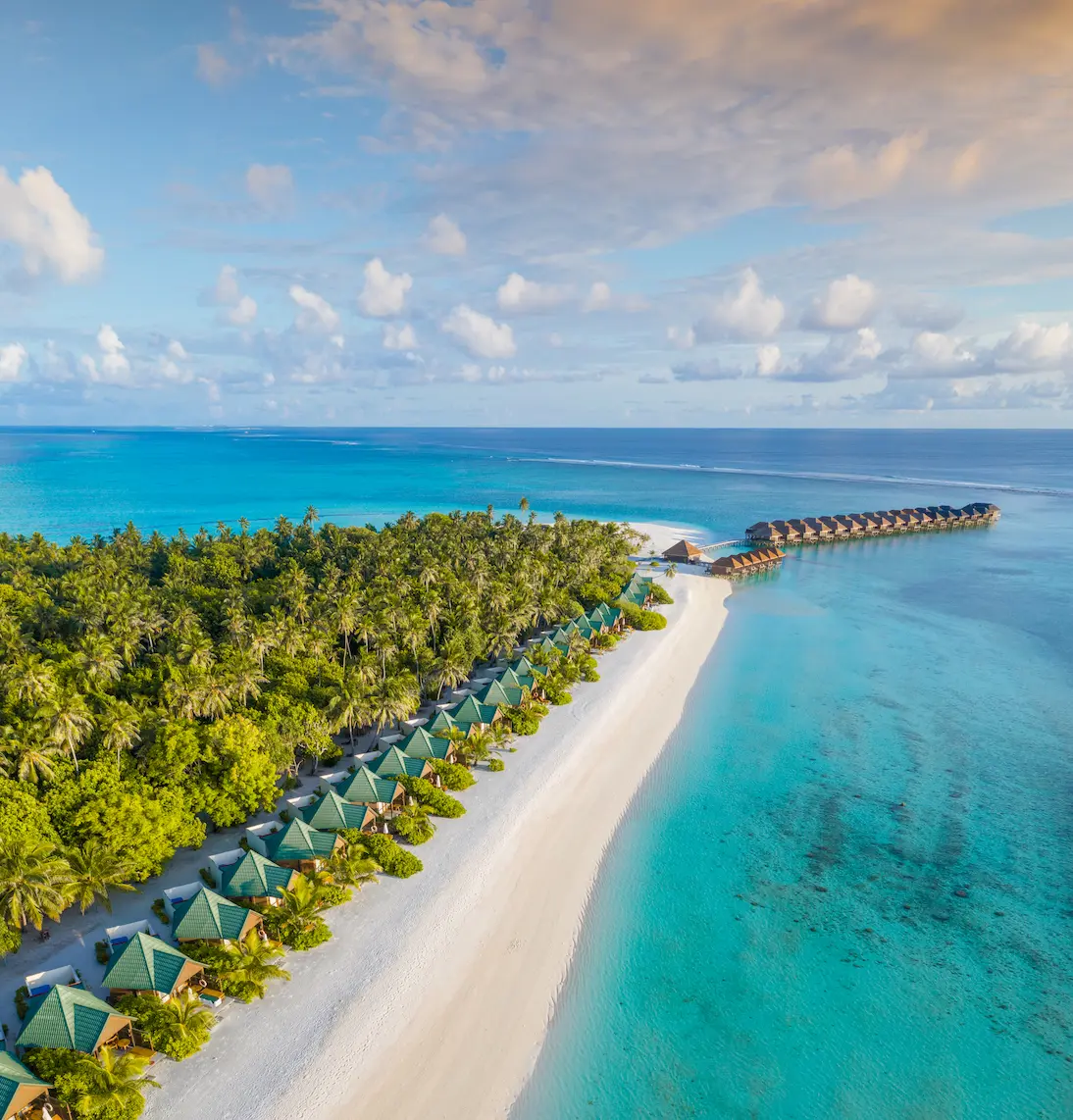 meeru maldives aerial beach villas view with turquoise lagoon soft natural light and a serene tropical shoreline highlighting the resort’s relaxed luxury atmosphere