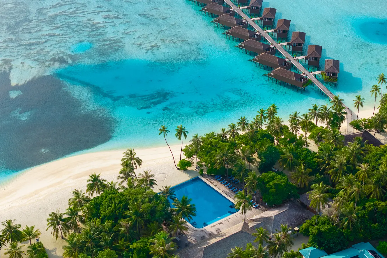 meeru maldives aerial beach view with turquoise lagoon soft natural light and a serene tropical shoreline creating a relaxed luxury island atmosphere