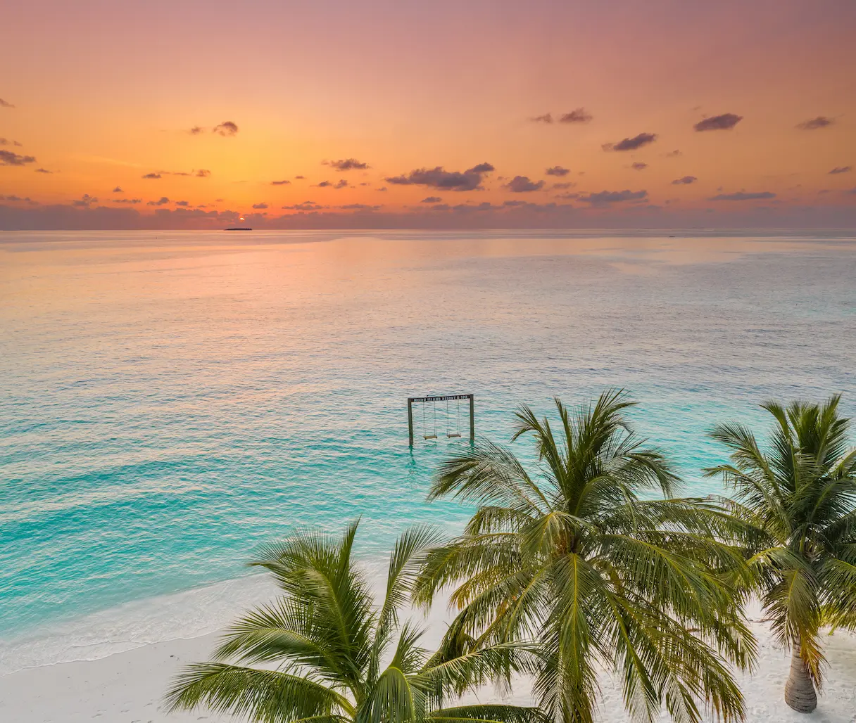 meeru maldives aerial swing view with turquoise lagoon soft natural light and a serene tropical shoreline creating a relaxed luxury island atmosphere