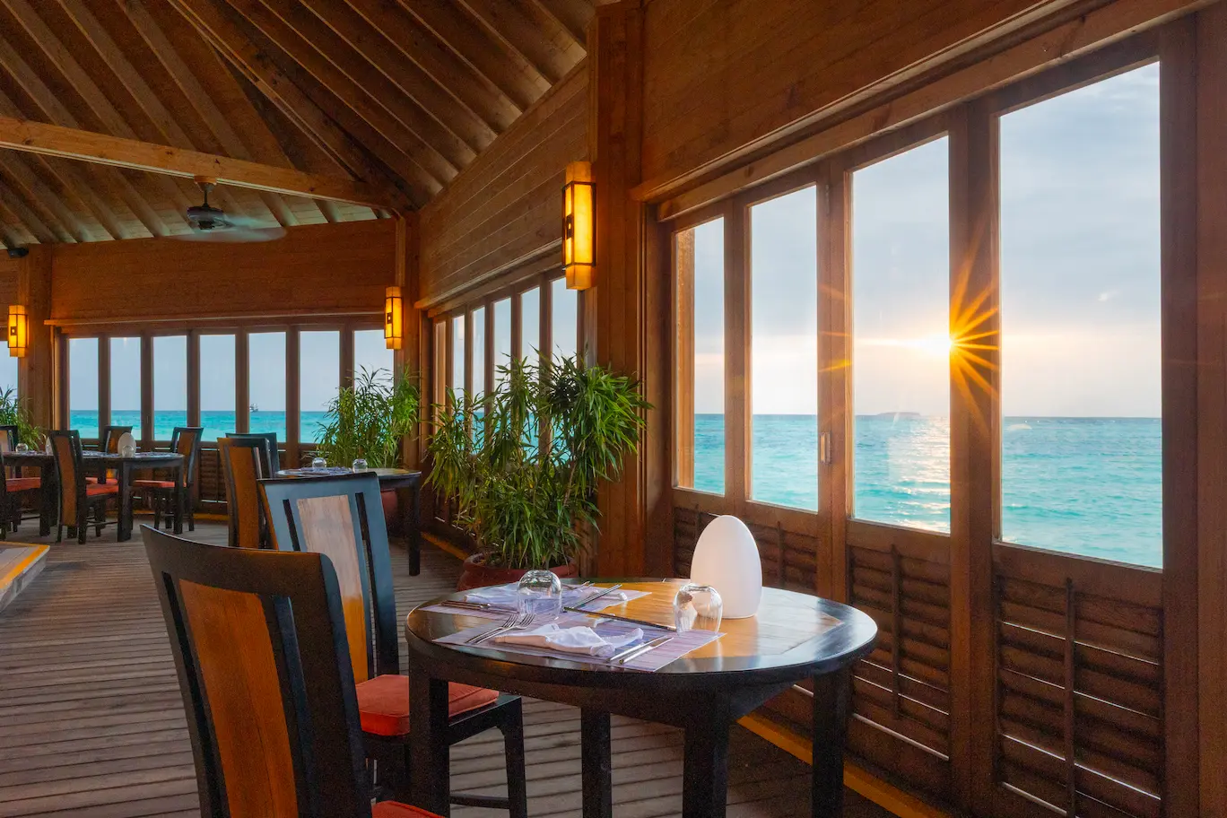meeru maldives asian wok interior with warm ambient lighting natural wood accents and a refined overwater dining atmosphere that reflects the resort’s relaxed luxury style