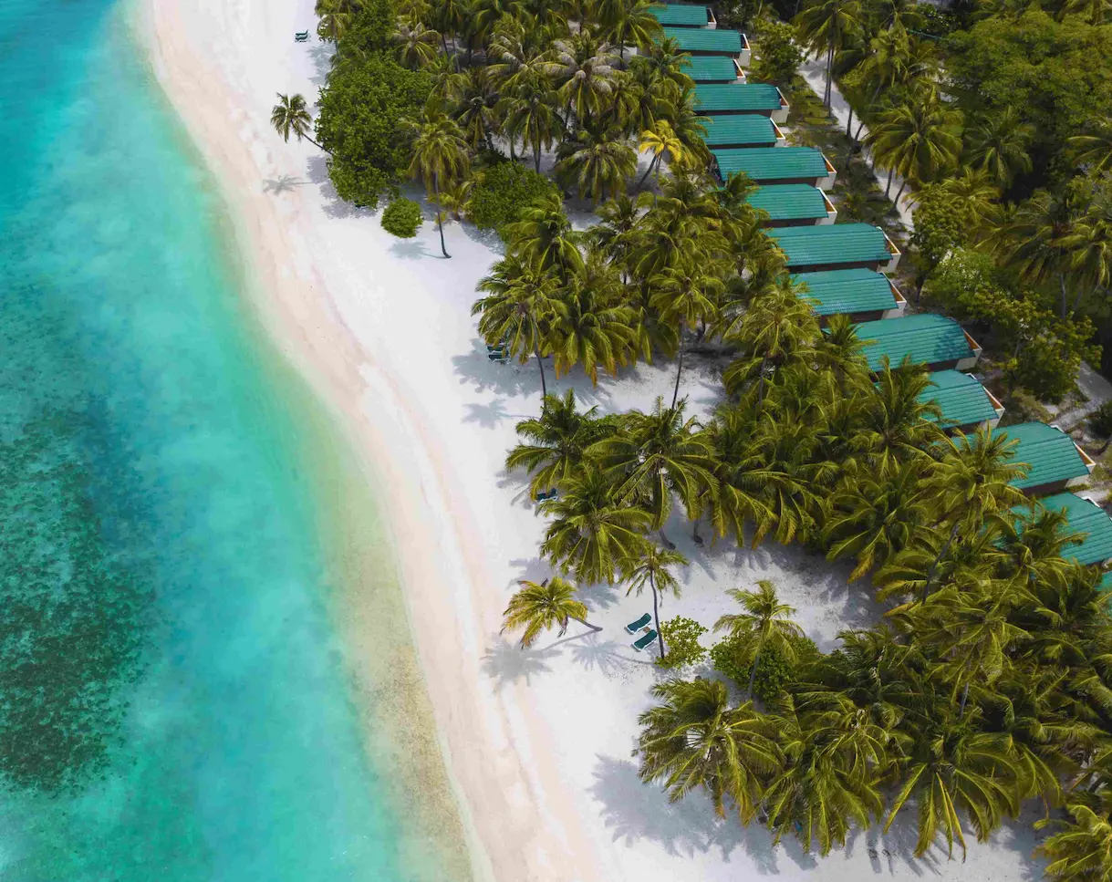 meeru maldives beach villa aerial view showing turquoise lagoon lush tropical greenery and the serene beachfront setting that highlights the resort’s relaxed luxury atmosphere