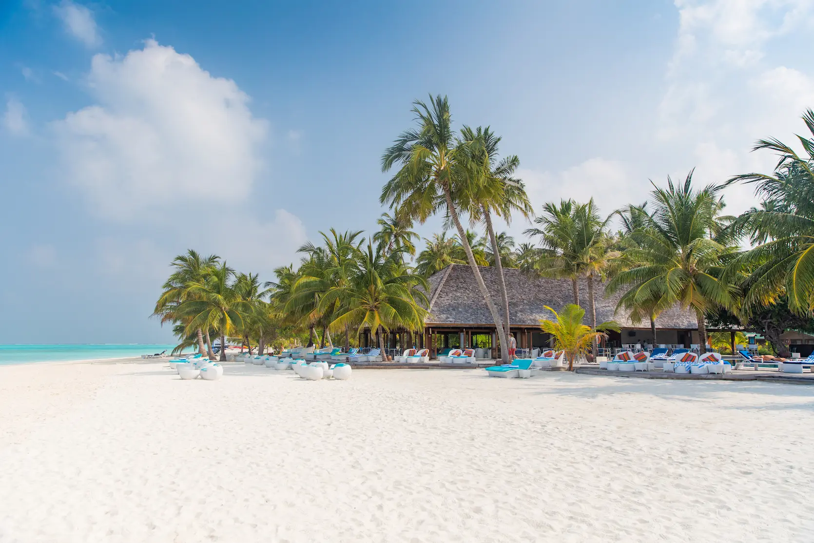 meeru maldives dhoni bar aerial view showcasing turquoise lagoon surrounding palm lined shoreline and a serene beachfront setting reflecting the resort’s relaxed luxury atmosphere