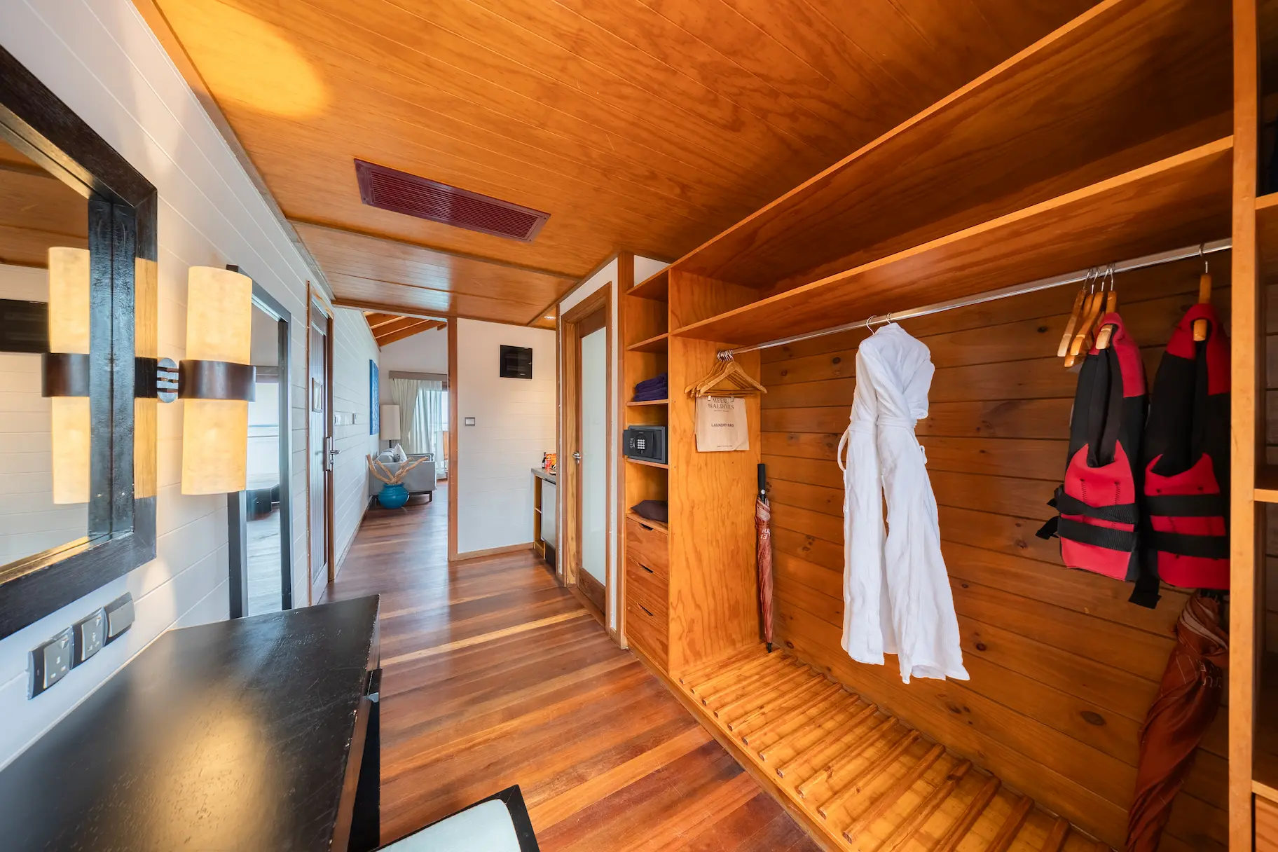 meeru maldives jacuzzi water villa interior wardrobe area with warm natural lighting soft wood finishes and a clean contemporary layout that enhances the resort’s relaxed luxury atmosphere