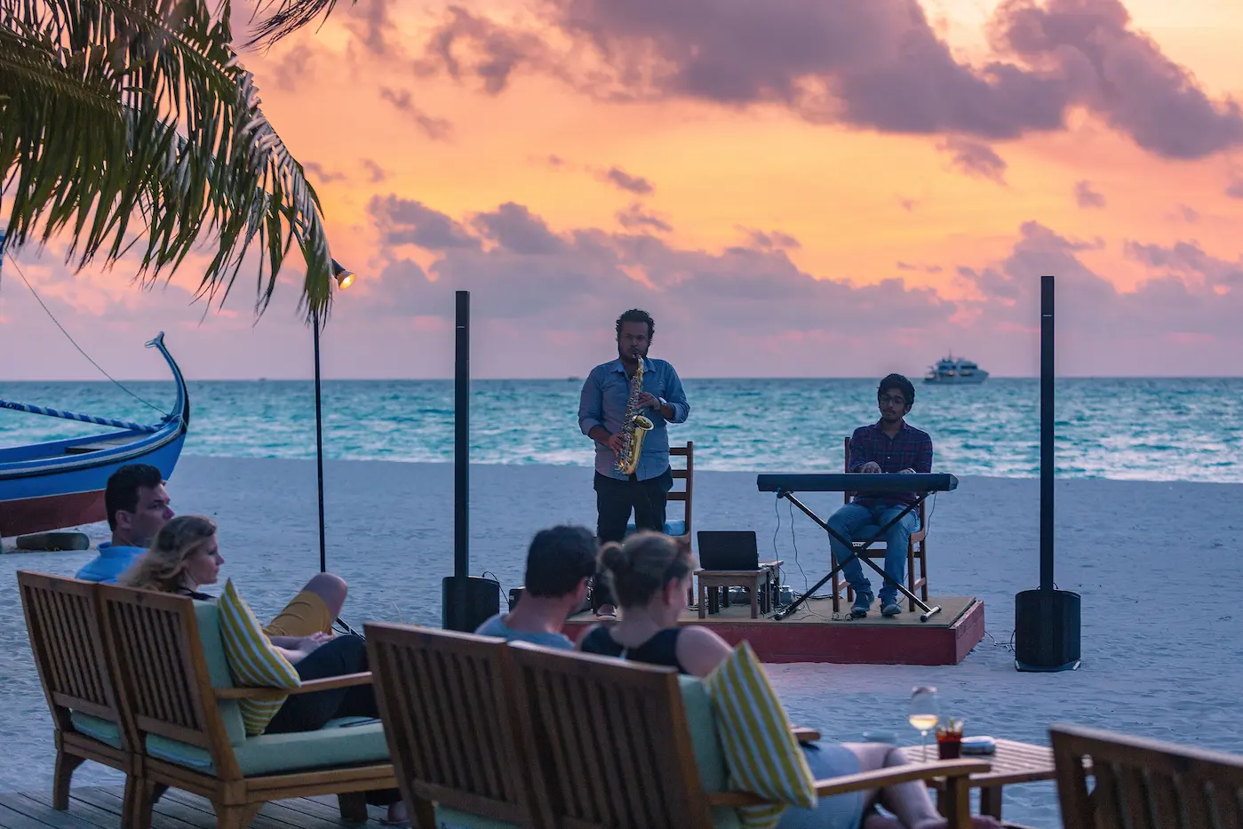 meeru maldives live band uthuru bar with warm sunset lighting gentle ocean breeze and a relaxed elegant beachfront atmosphere creating a refined evening experience