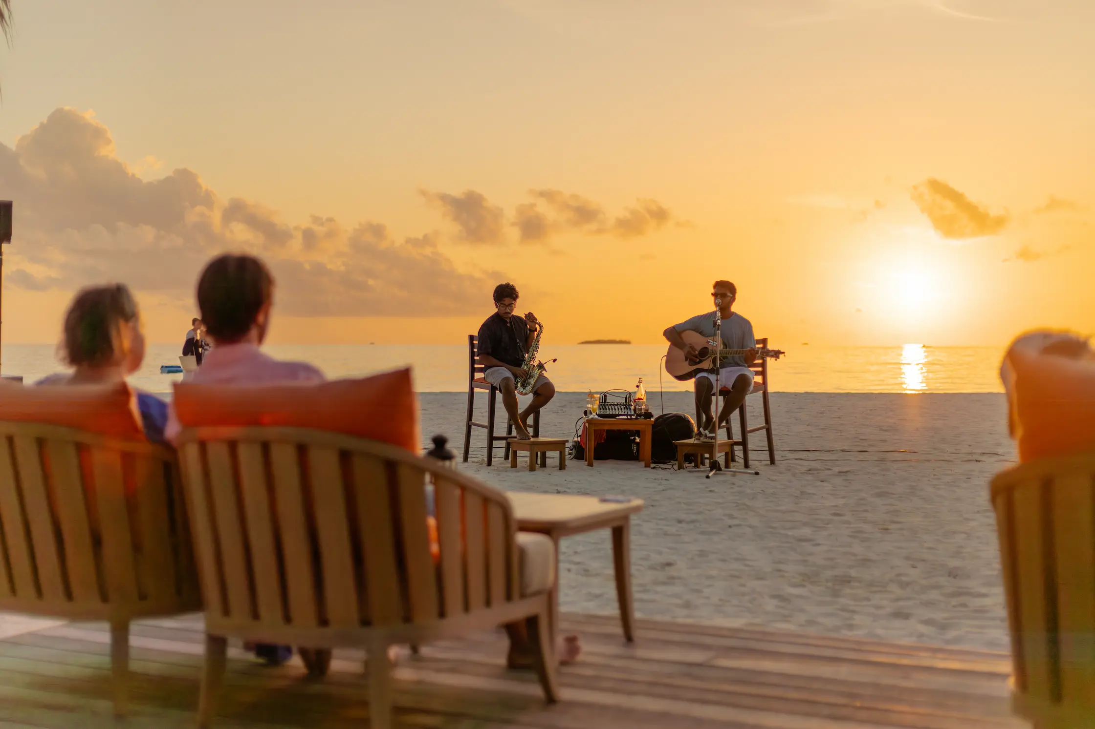 meeru maldives uthuru bar sunset live music scene with warm golden light gentle ocean views and a relaxed elegant beachfront atmosphere reflecting the resort’s refined luxury style