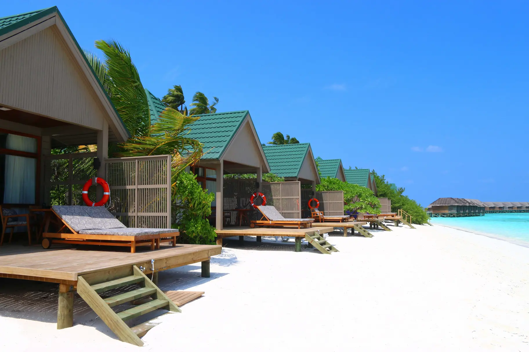 meeru maldives waterfront villa exterior with soft natural light tropical greenery and a calm elegant beachfront setting reflecting the resort’s relaxed luxury atmosphere
