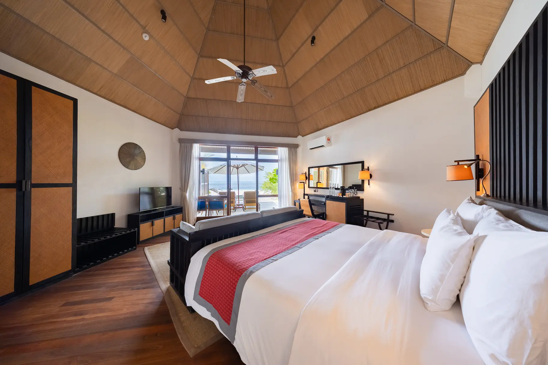 meeru maldives waterfront villa interior bed with view featuring soft natural daylight warm wood textures and a serene lagoon outlook that enhances the resort’s relaxed luxury atmosphere