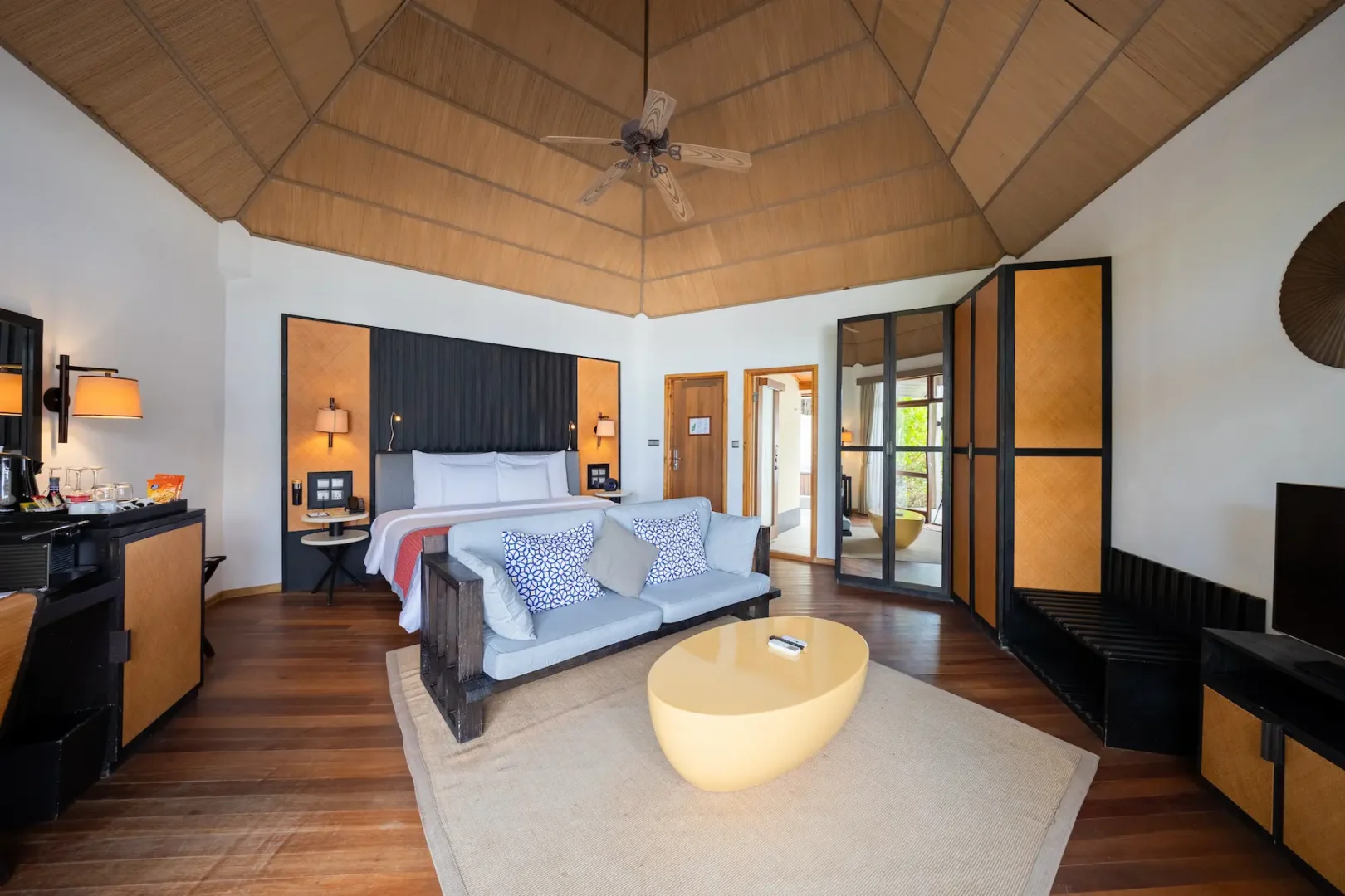 meeru maldives waterfront villa interior bedroom with soft natural lighting warm wood textures and a serene contemporary design that enhances the resort’s relaxed luxury atmosphere