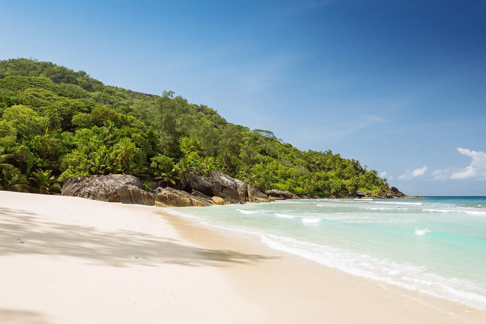 niva labriz seychelles beach with white sand and turquoise water surrounded by tropical greenery
