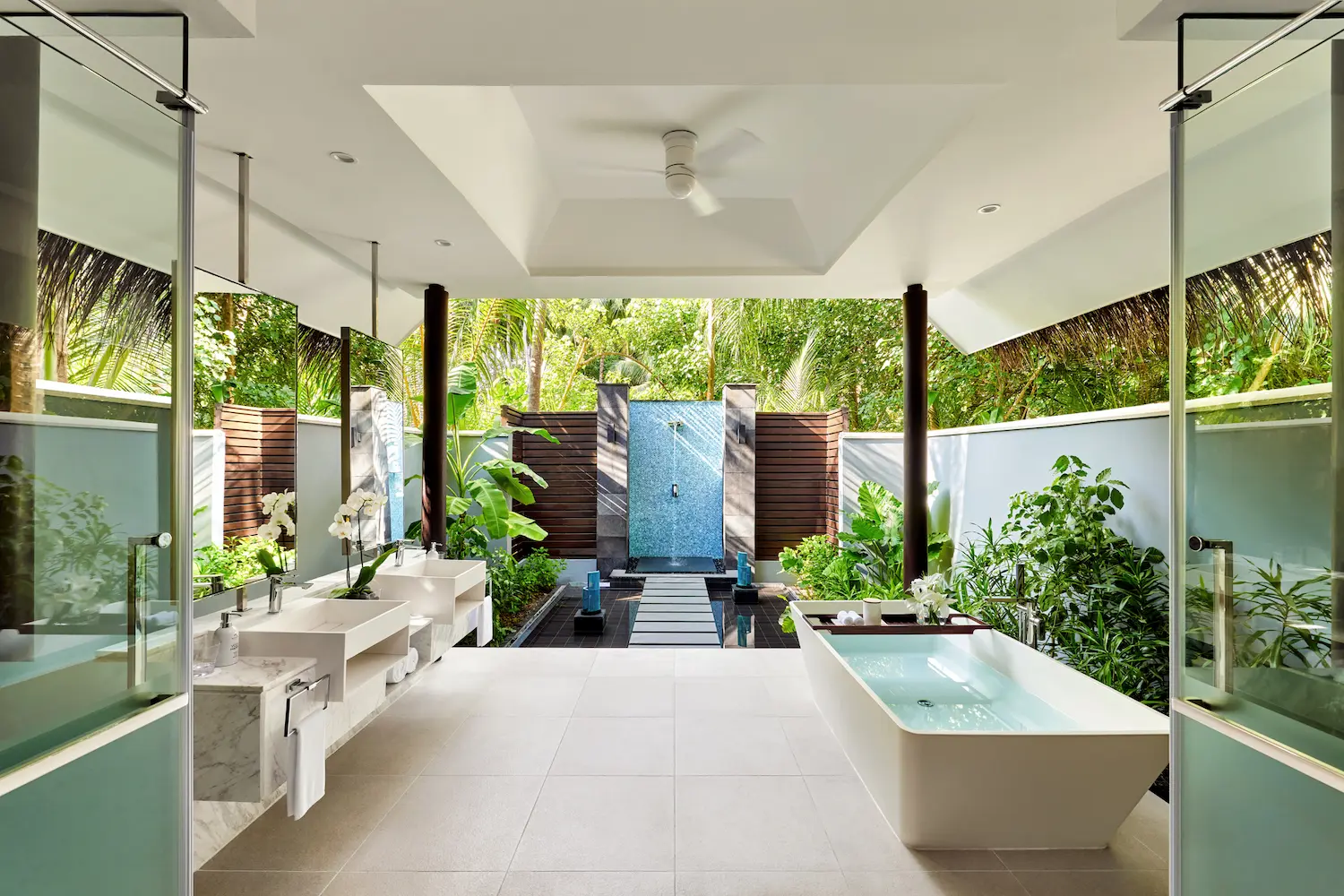 niyama private islands maldives deluxe beach pool villa bathroom featuring a serene luxury space with natural textures soft lighting and an elegant island ambiance