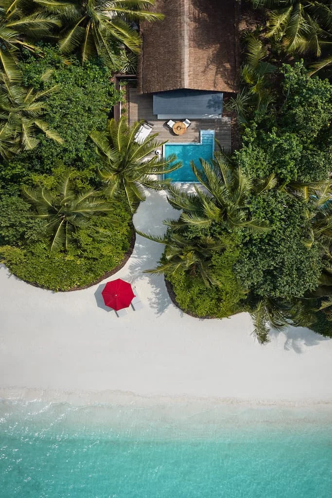 niyama private islands maldives deluxe beach pool villa beach front aerial view showcasing pristine shoreline and elevated island luxury