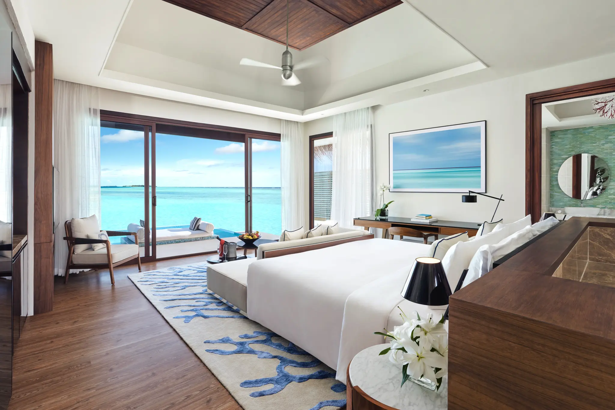 niyama private islands maldives deluxe over water pool villa bedroom featuring refined ocean inspired interiors and tranquil contemporary island luxury
