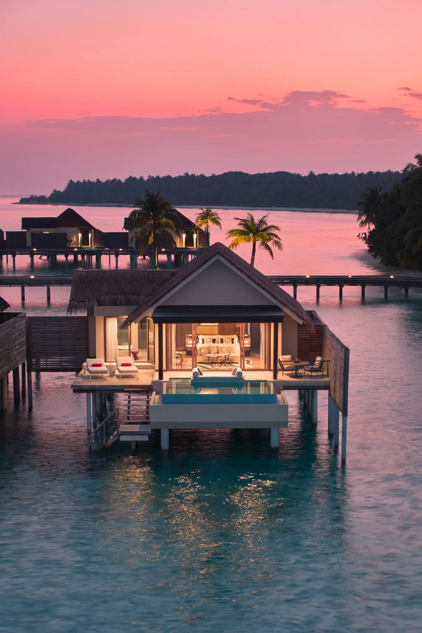 niyama private islands maldives over water pool villa exterior bliss by sunset showcasing warm twilight hues and serene oceanfront elegance