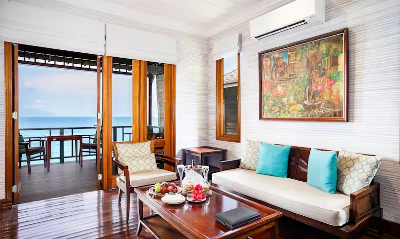 sofa seating area in northolme king premium oceanfront villa with modern furniture, tropical decor, and ocean view through large windows