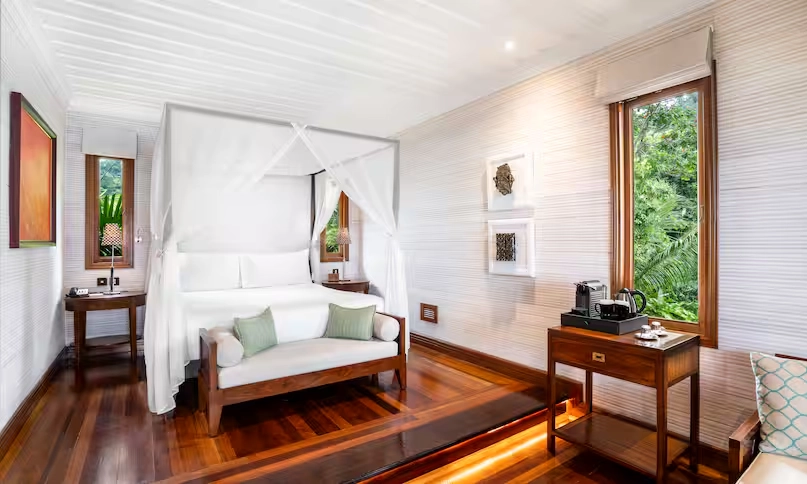 bedroom in northolme king sunset villa with king bed, tropical decor, large windows, and ocean view