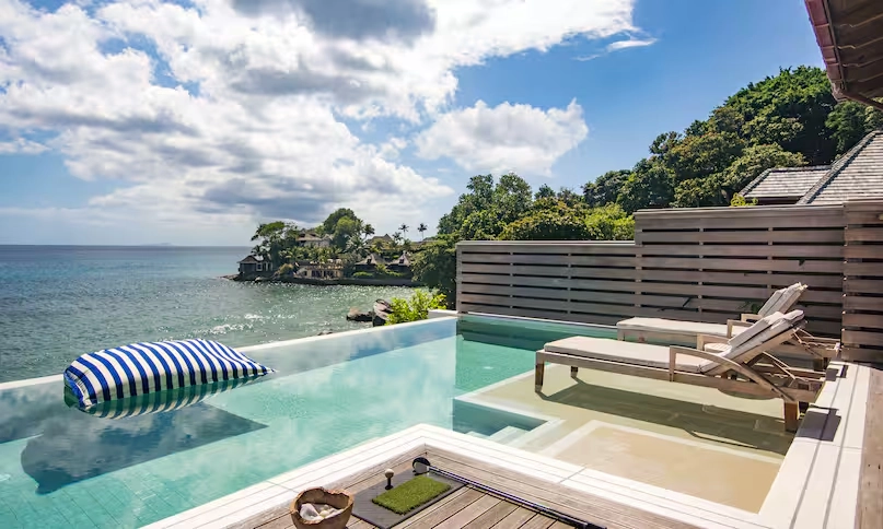 poolside loungers at northolme signature grand ocean pool villa with infinity pool, tropical views, and panoramic ocean scenery