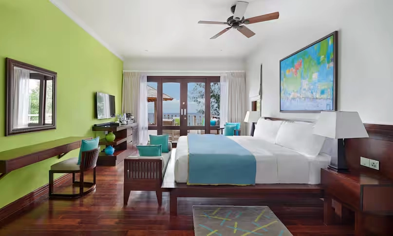 bedroom in northolme two bedroom oceanfront pool villa with king bed, tropical decor, large windows, and panoramic ocean view