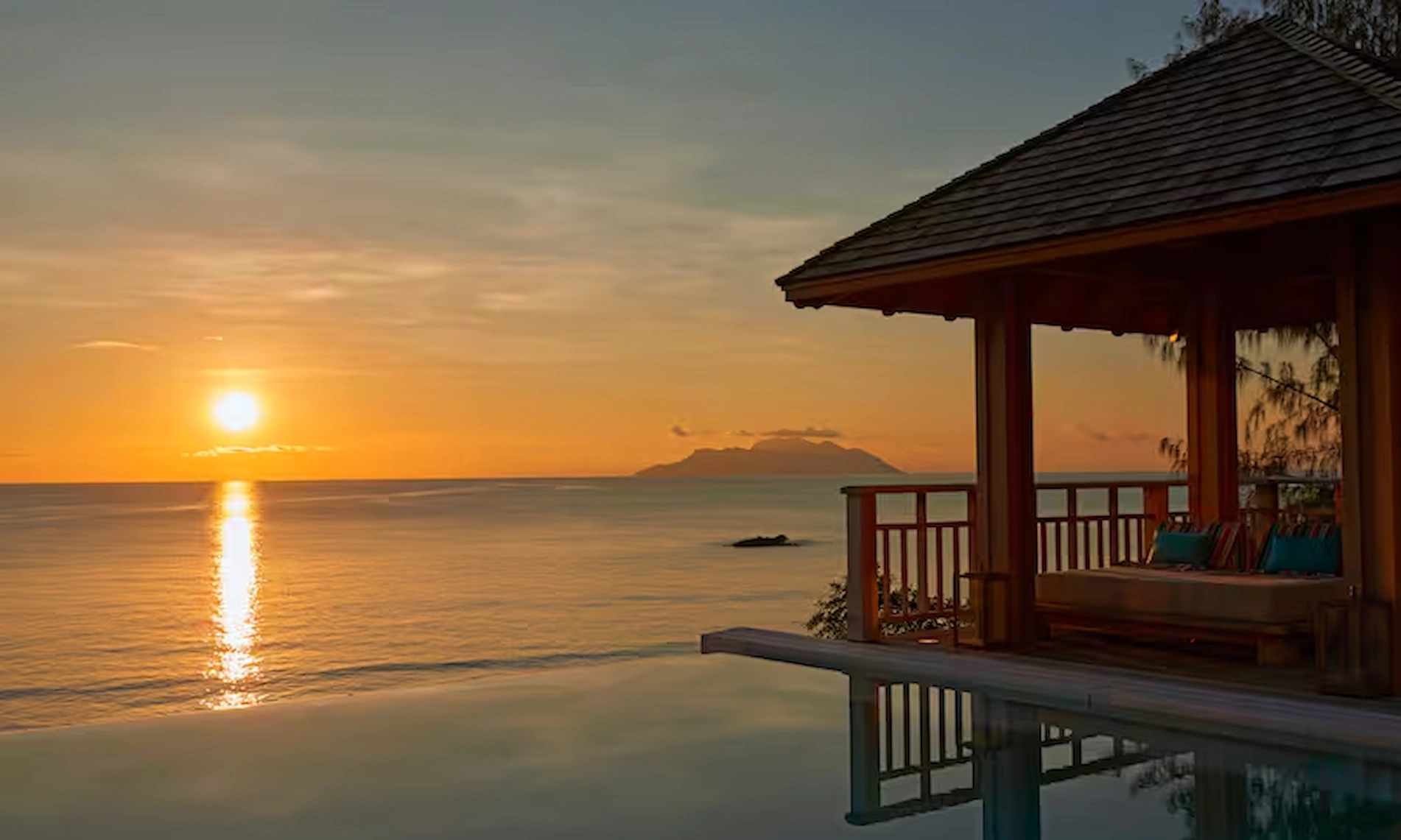 sunset view from northolme two bedroom oceanfront pool villa with infinity pool, tropical surroundings, and panoramic ocean scenery