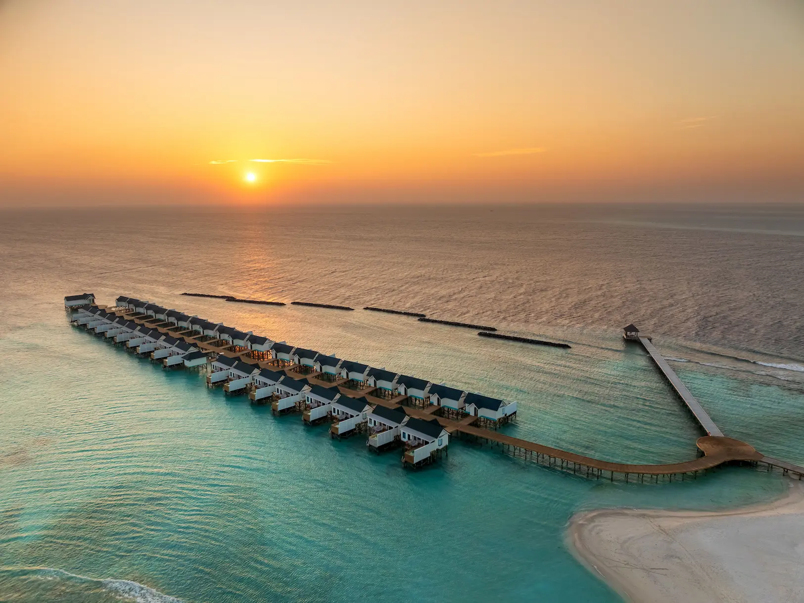 oblu nature helengeli water villa with pool sunset aerial showing serene overwater villas warm golden light and a calm island atmosphere