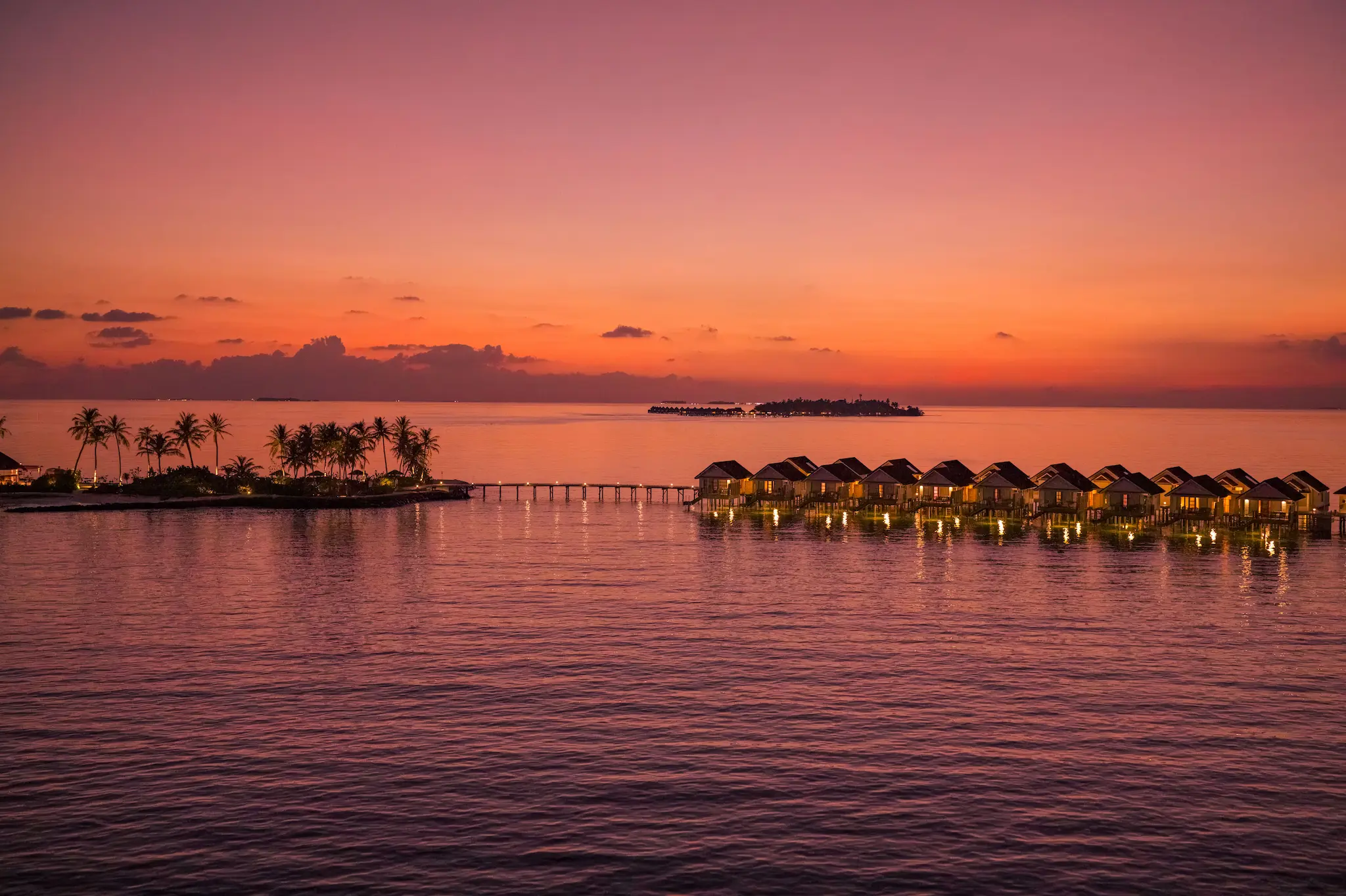 oblu select lobigili maldives island aerial sunset nest water villa dramatic sunset aerial highlighting nest water villa over turquoise lagoon with warm golden light and serene tropical ambience