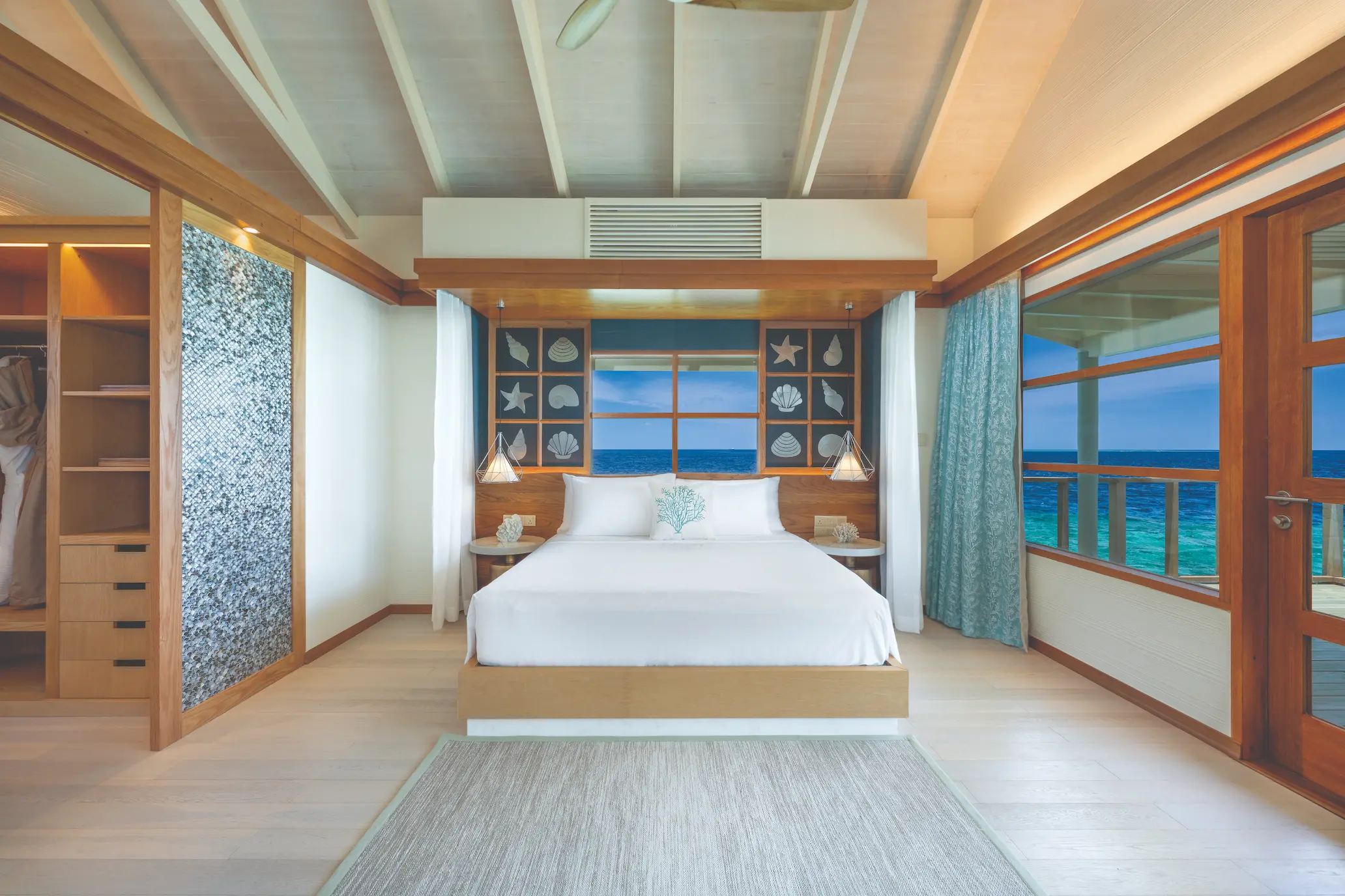oblu select lobigili maldives nest water villa bedroom three interior stylish overwater bedroom interior with warm wood accents calm lagoon backdrop and elegant island design