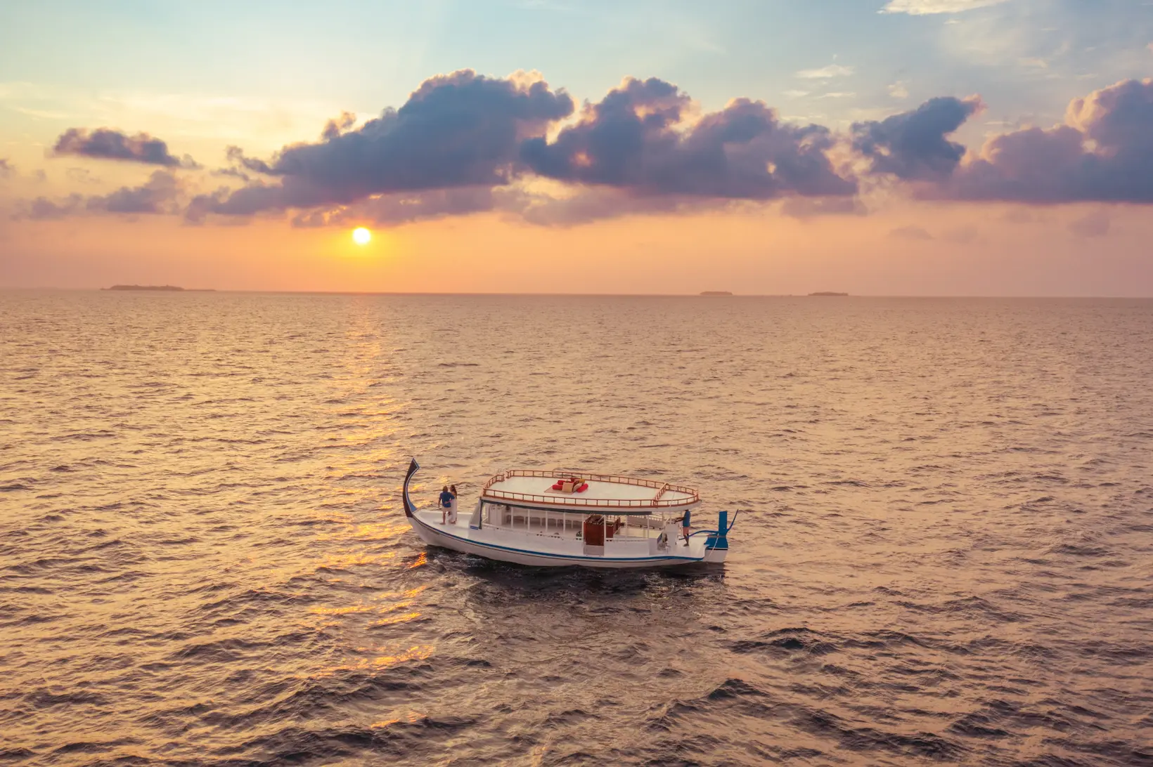 oblu select lobigili maldives romantic sunset cruise intimate ocean cruise at golden hour with soft tropical light and serene island ambience