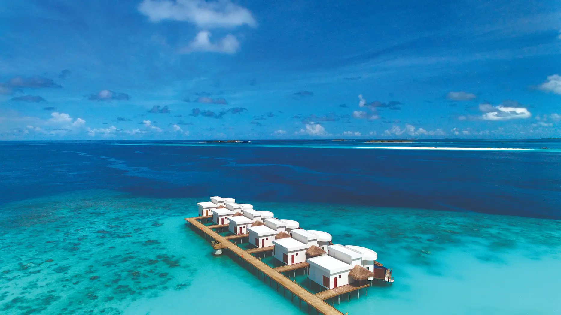 oblu select sangeli maldives honeymoon ocean suite bedroom segment refined overwater bedroom segment with warm natural textures soft ambient lighting and serene lagoon ambience