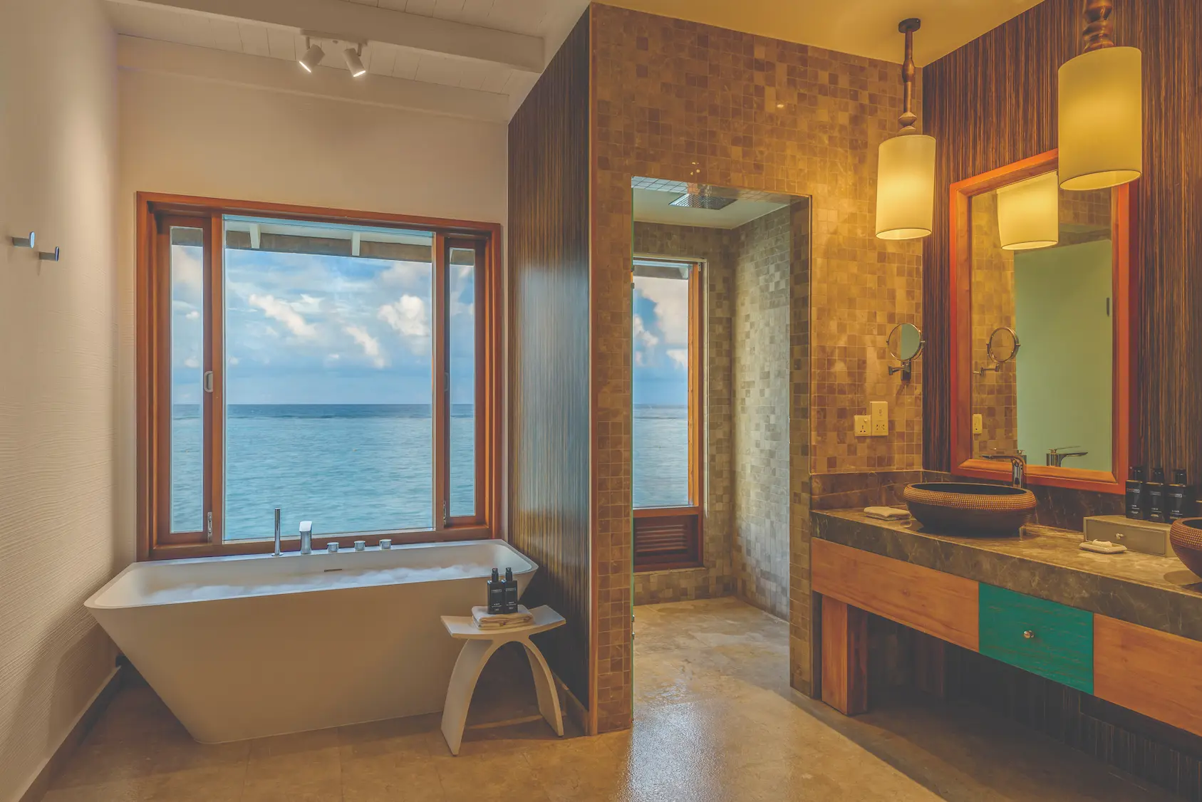 oblu select sangeli maldives water villa bathroom view elegant overwater bathroom with serene lagoon backdrop natural textures and refined tropical ambience