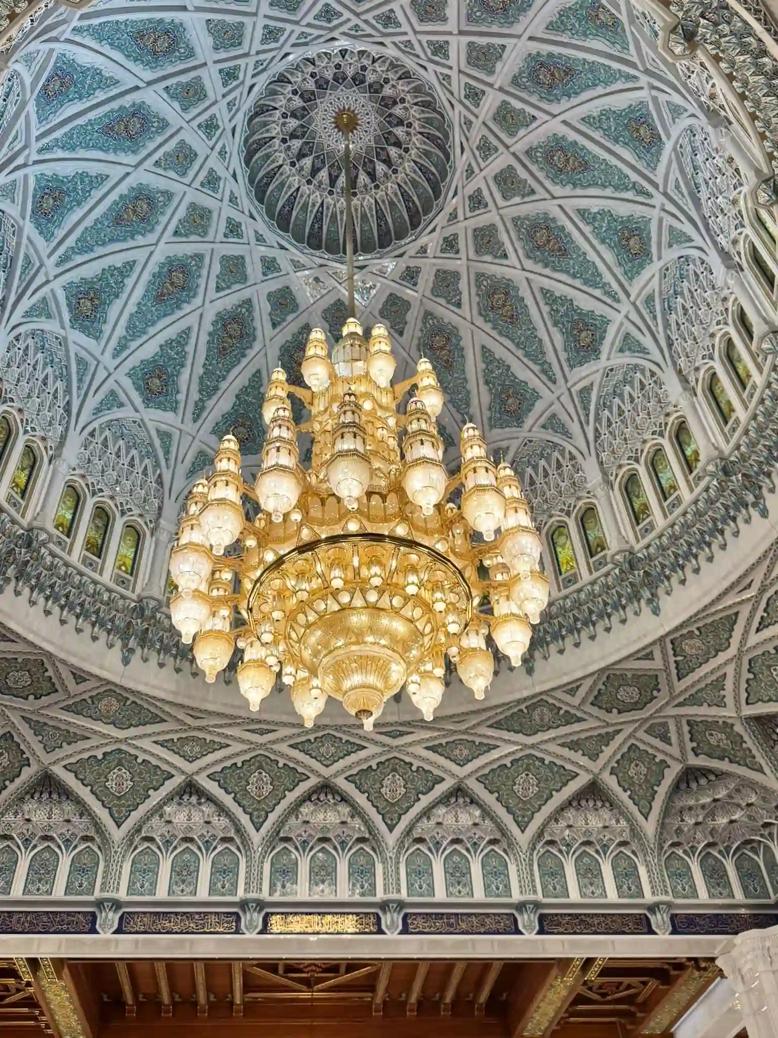 oman mosque ceiling with intricate arabesque patterns, geometric designs, and ornate chandeliers creating a stunning decorative interior