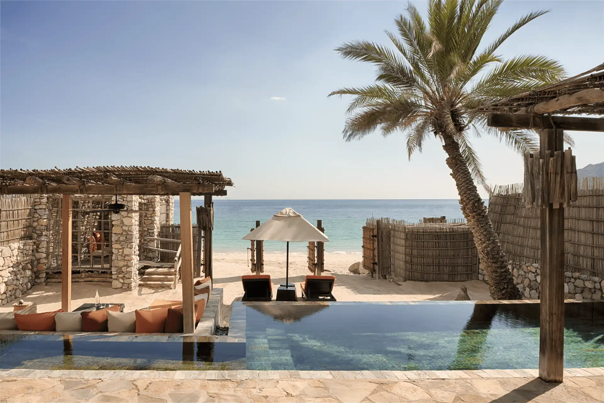 poolside area of beachfront pool villa suite at six senses zighy bay oman resort