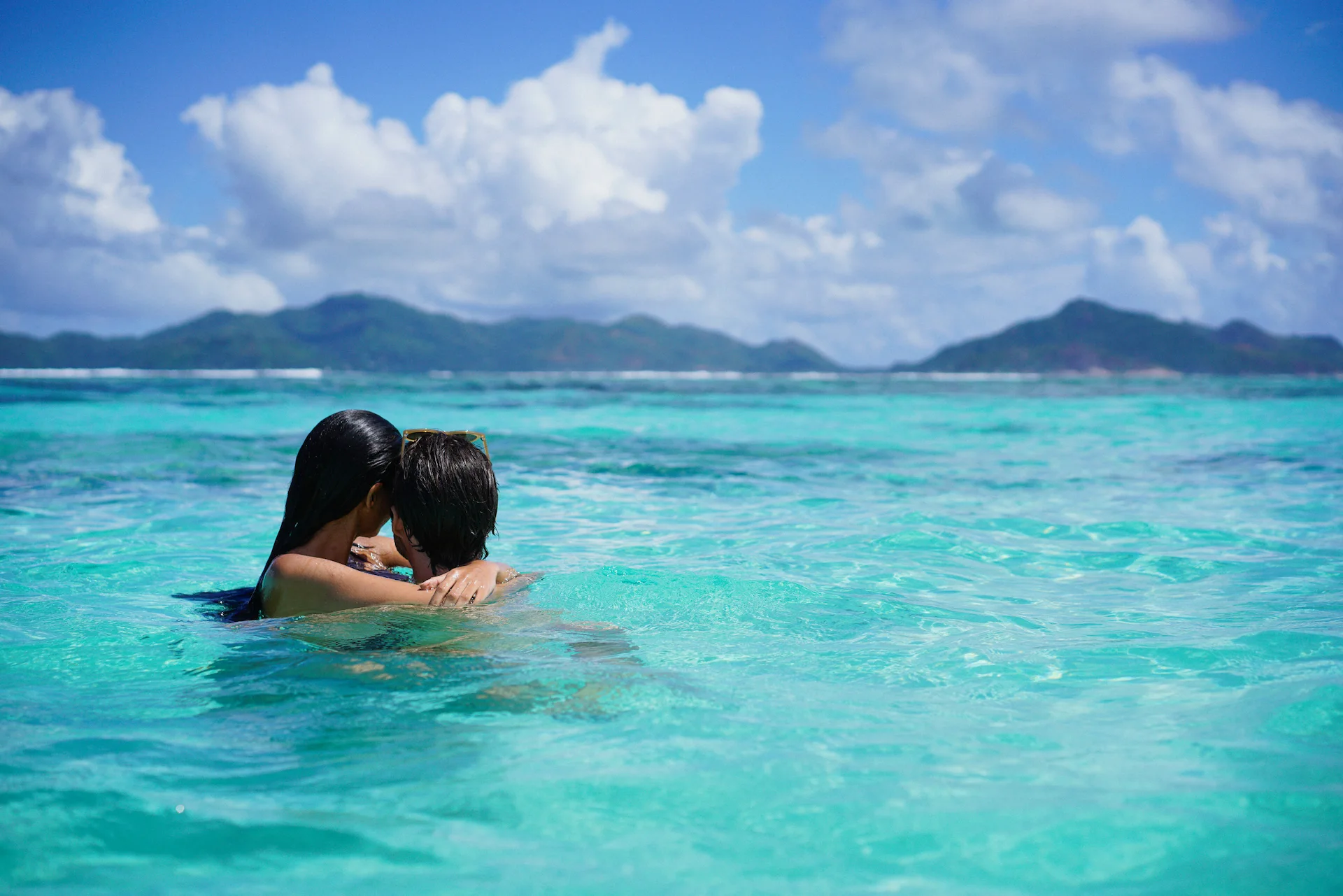honeymoon couple enjoying the sea at raffles seychelles with turquoise waters and tropical surroundings